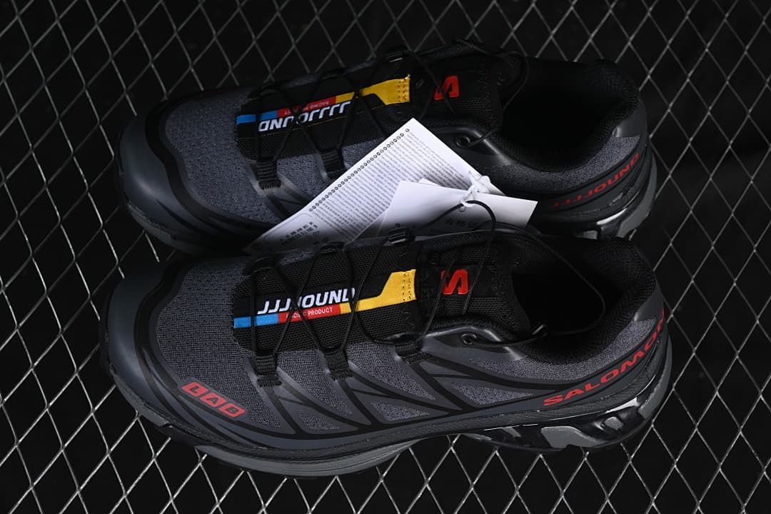 Pair of dark gray and black sneakers with red accents