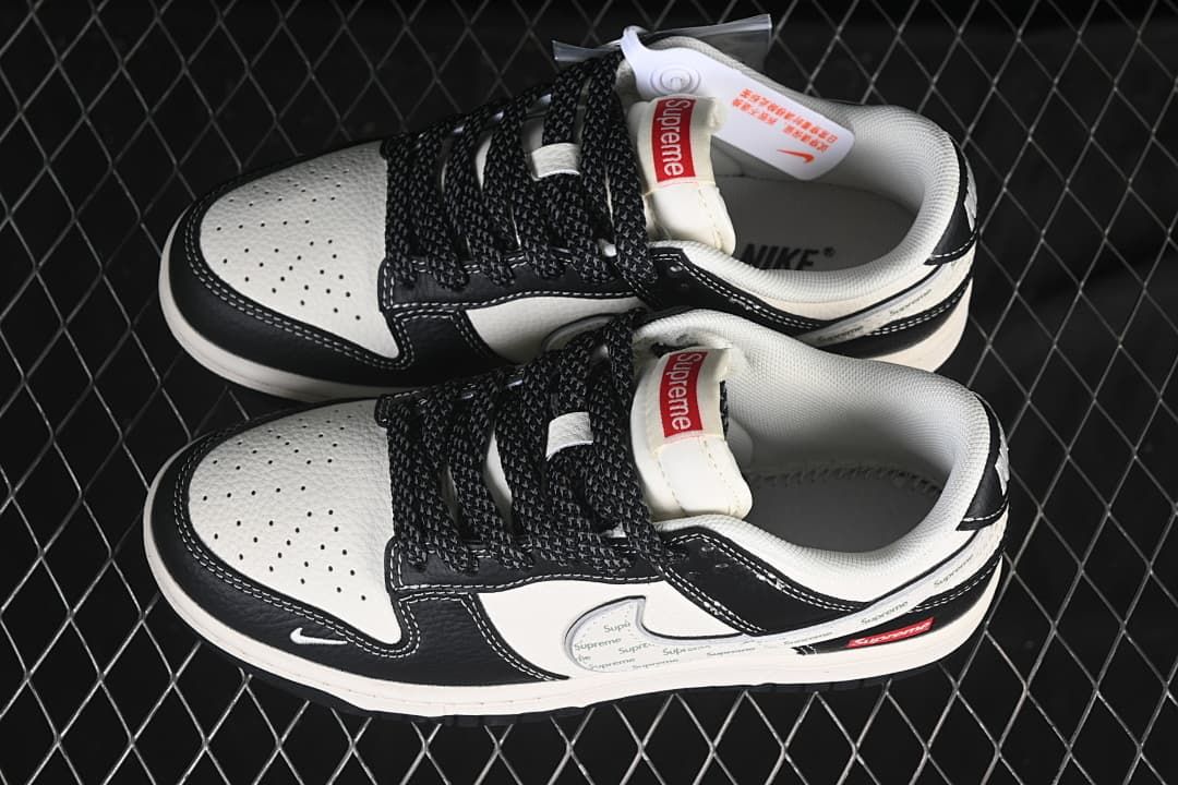 Top view of a pair of black and white Nike SB Dunk Low sneakers with patterned side panels