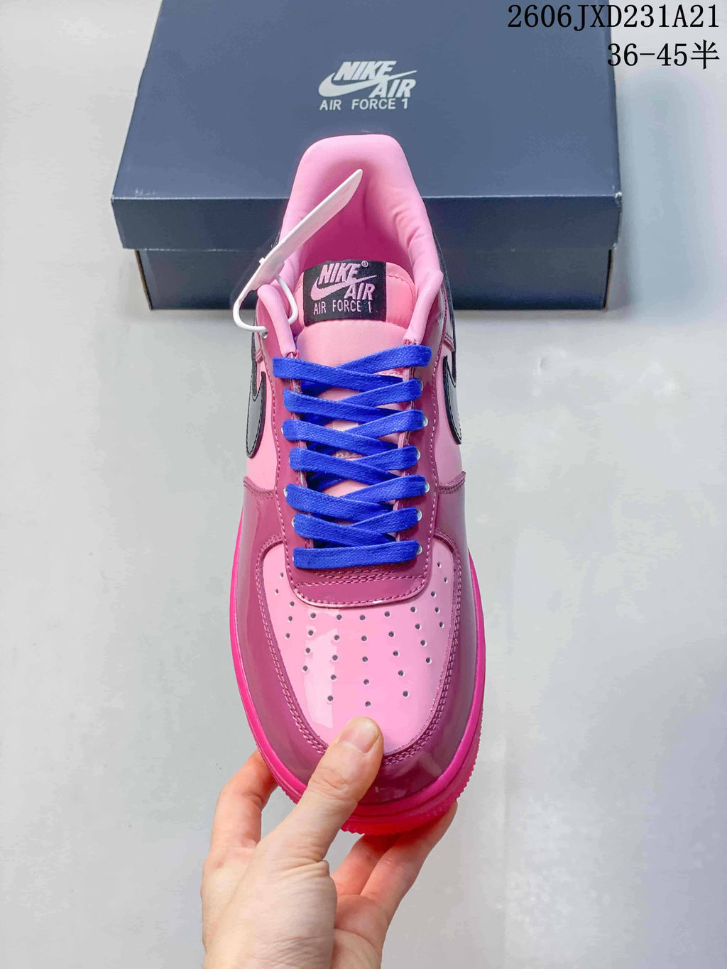 Top view of a pink Nike Air Force 1 sneaker showing its perforated toe and blue laces
