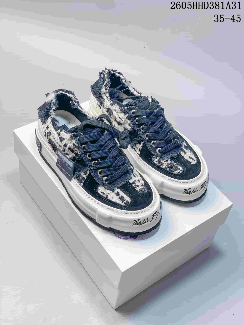 Pair of navy and cream patterned xVESSEL G.O.P. Low sneakers viewed from the front at an angle.