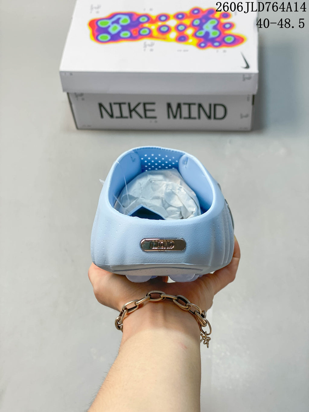 Rear view of the light blue mule showing its open heel and NOCTA badge