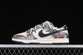 Side view of low-top sneakers with black, gray, and ivory patterned panels and red accents