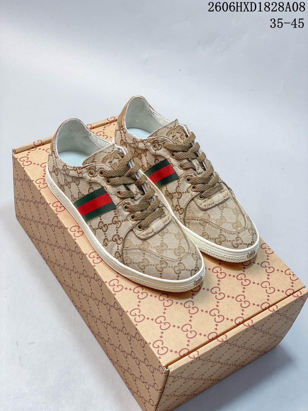 Pair of beige GG-patterned low-top sneakers with green-and-red side stripes and off-white soles