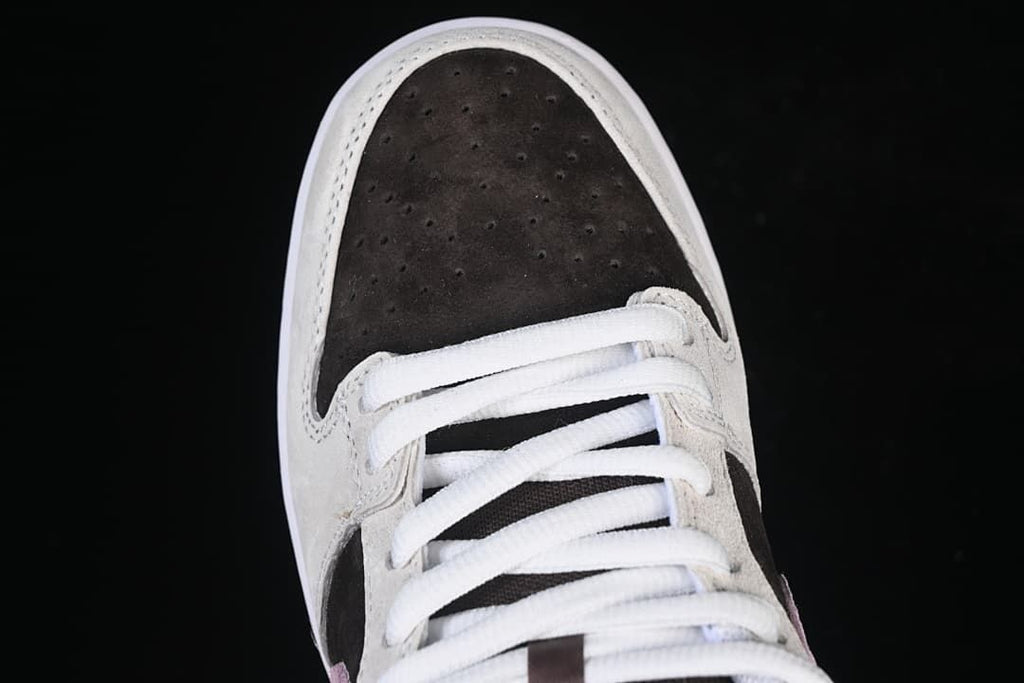 Top view of the perforated dark brown toe box and white laces