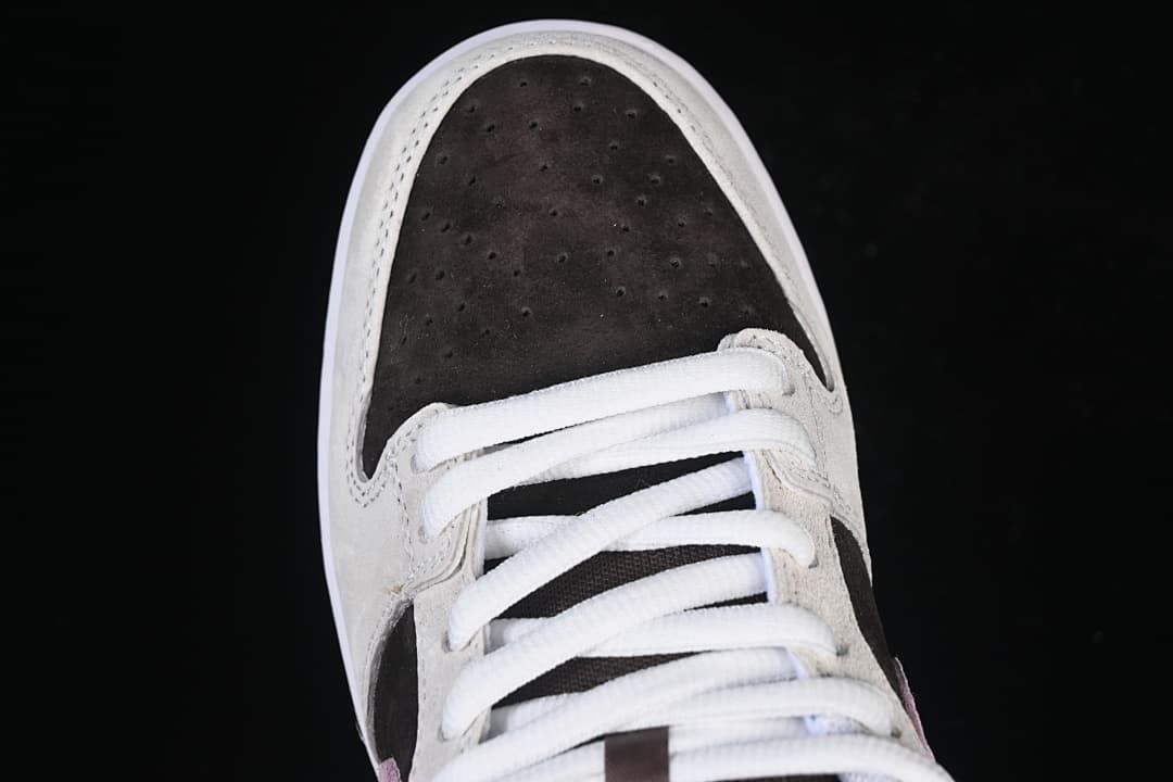 Top view of the perforated dark brown toe box and white laces