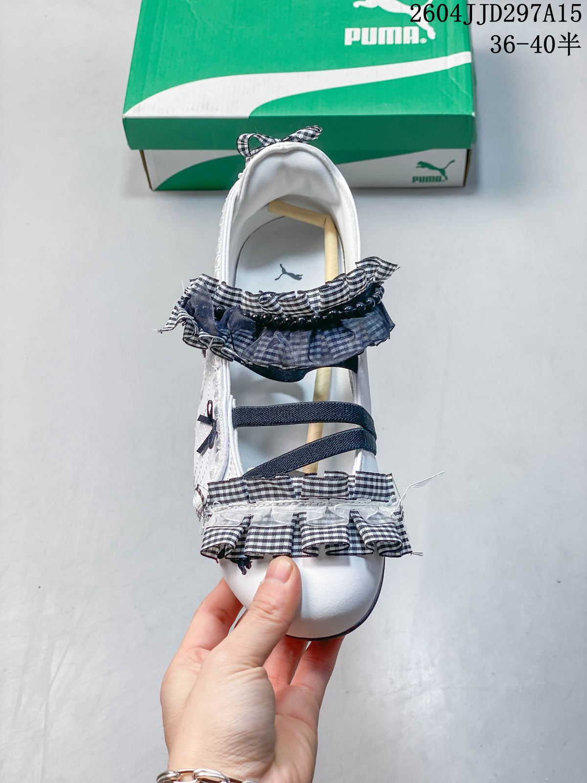 Top view of a white flat with dark straps, gingham ruffles and bows.