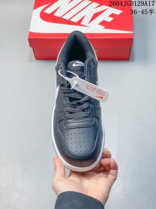 Front view of a black and white Nike low-top sneaker showing the perforated toe area and laces.