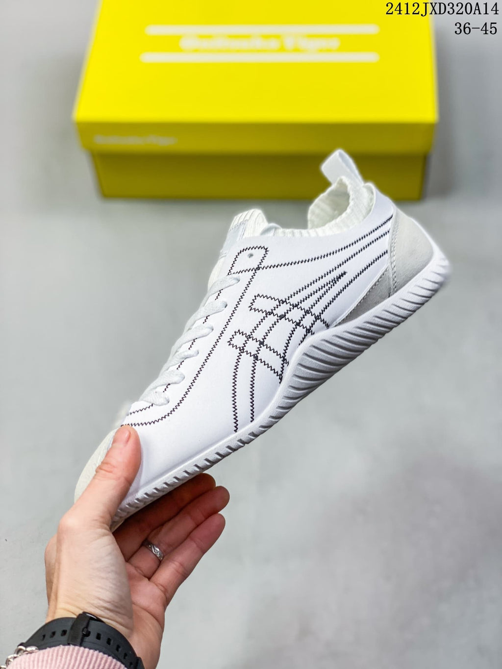 Side view of the white sneaker with black stitched details and textured outsole