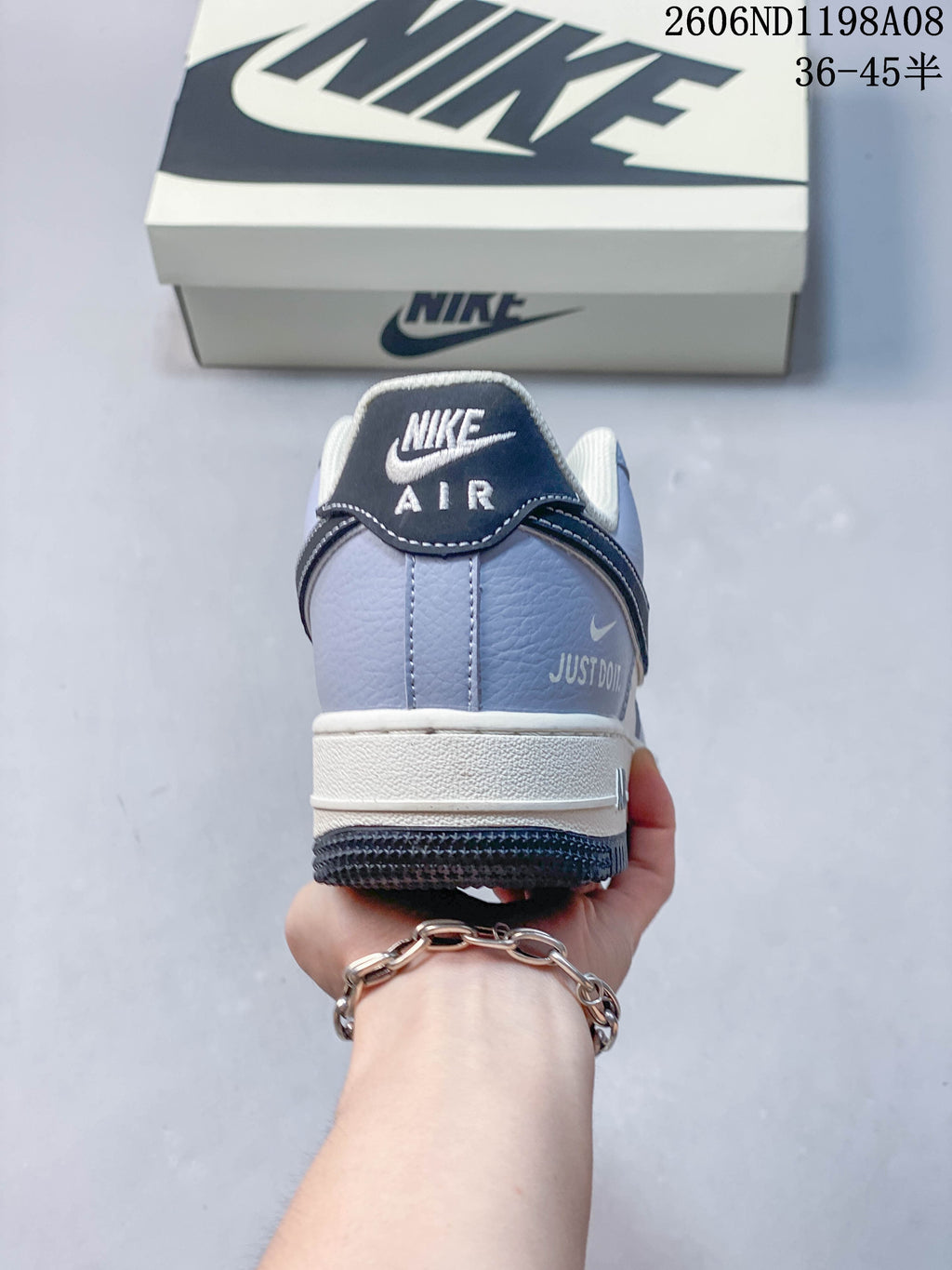 Rear view of a light-blue sneaker with dark heel trim, white midsole, and dark outsole; image overlay shows code 2606ND1198A08 and size range 36–45.5.
