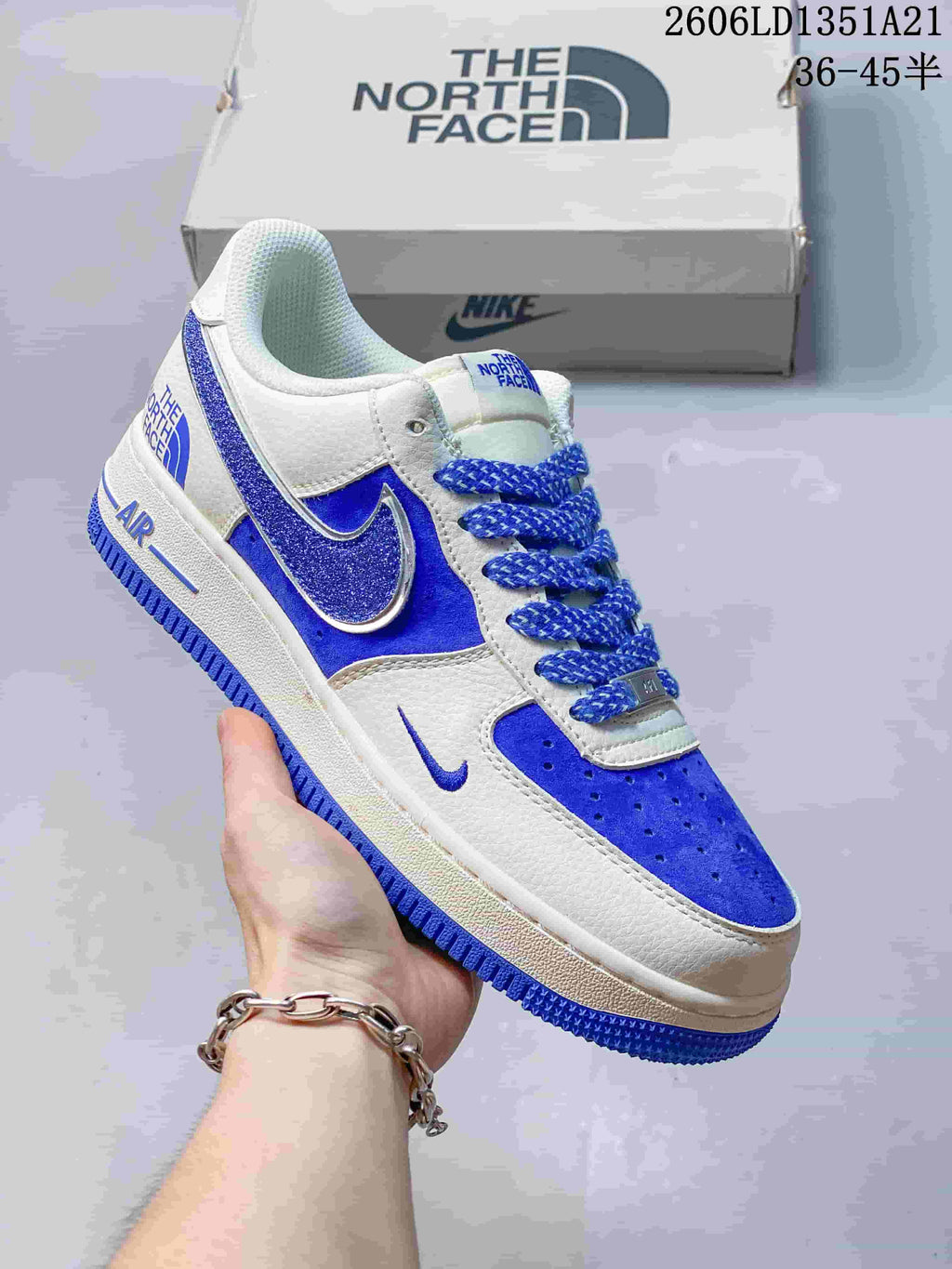 White low-top sneaker with blue glitter Swoosh, vivid blue accents, and blue laces