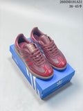 Pair of burgundy and red Adidas Samba OG sneakers on a blue box