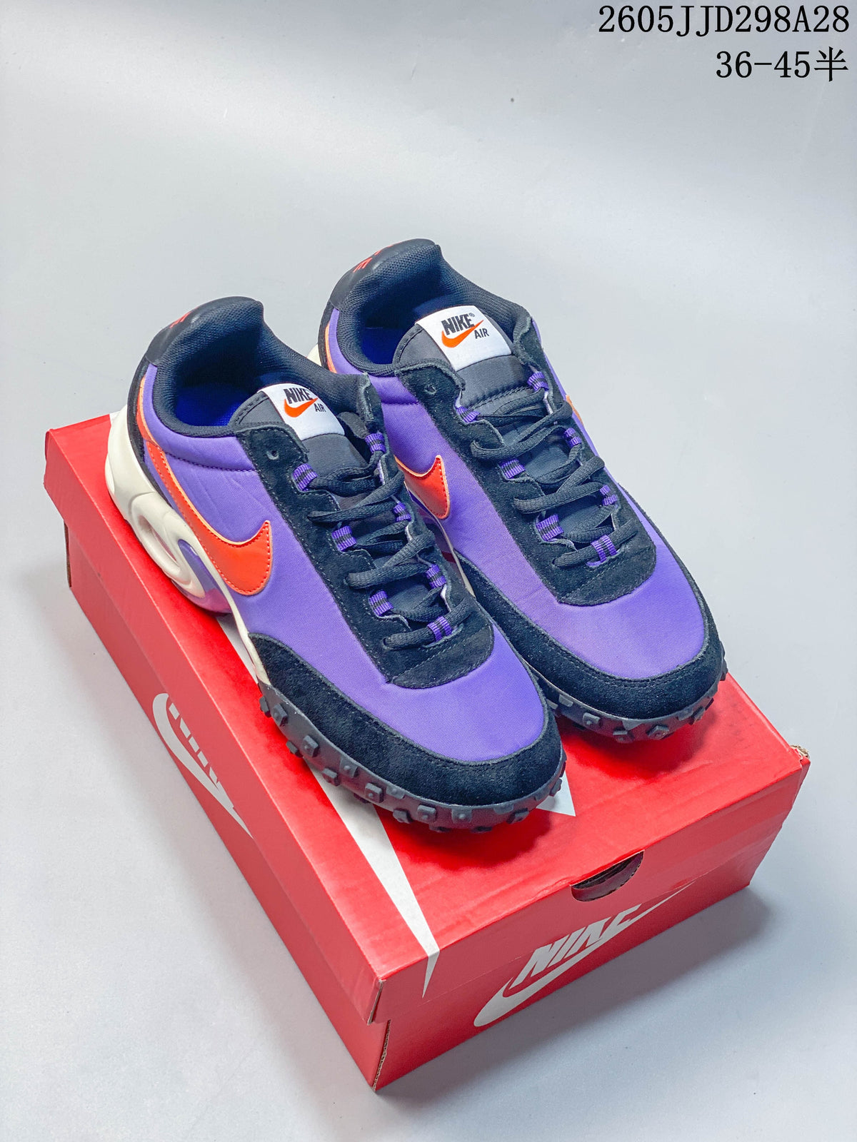 Nike Air Max Waffle SP sneakers in purple, navy, and orange, shown on a red shoe box