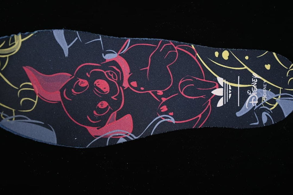 Close-up of a dark patterned insole with character artwork and Disney lettering.