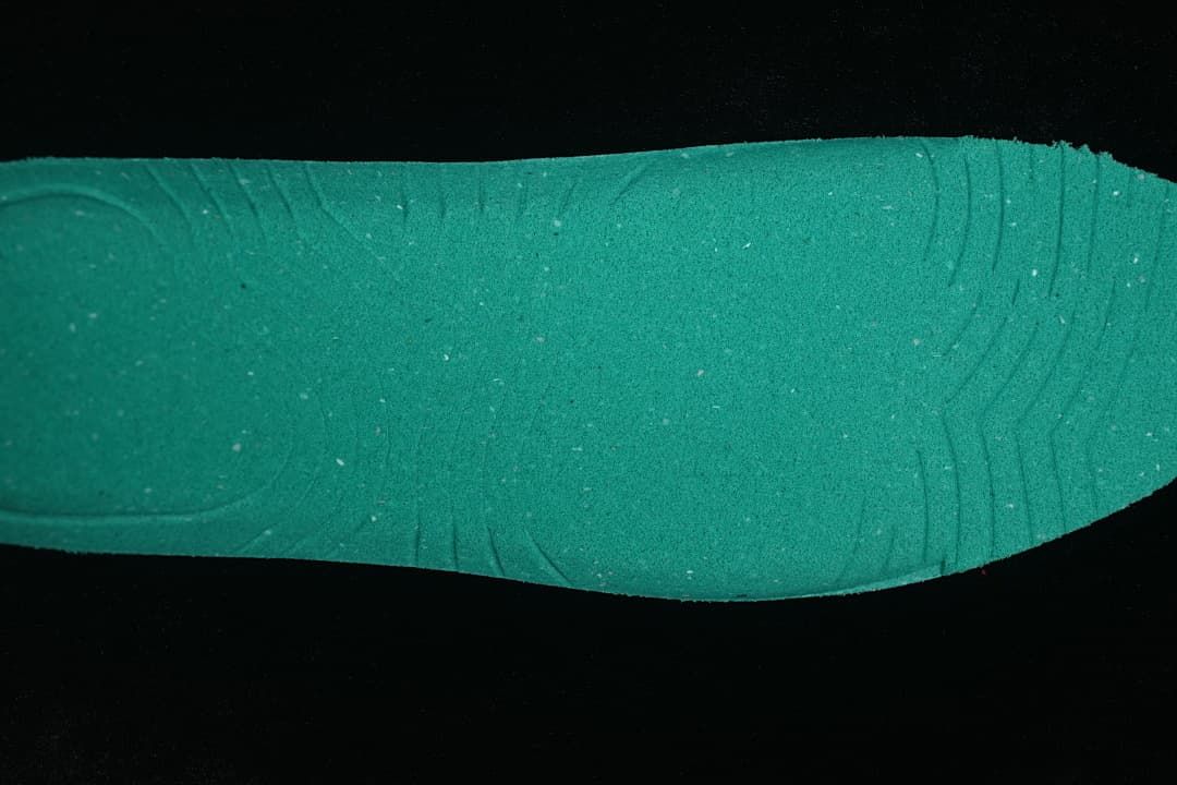 Green shoe insert shown against a dark background
