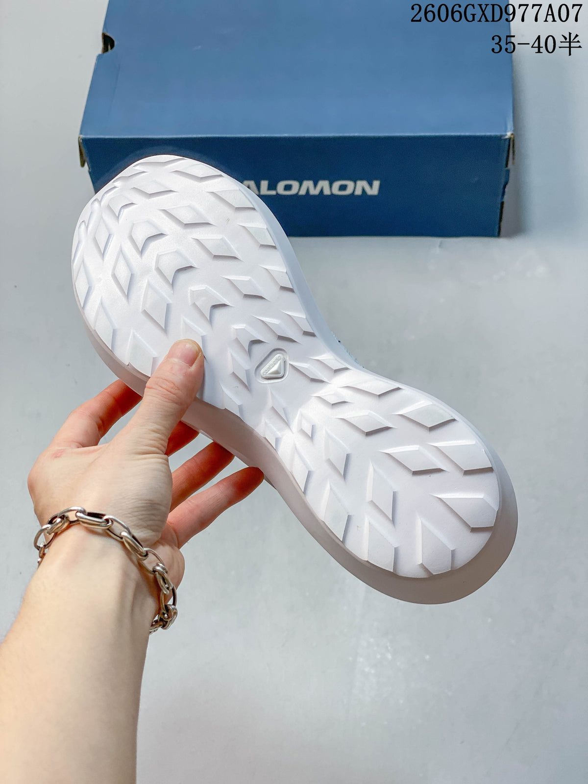View of the white sneaker outsole, showing a raised geometric tread pattern.