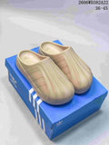 Pair of beige Adidas Adifom Superstar clogs on a blue shoebox