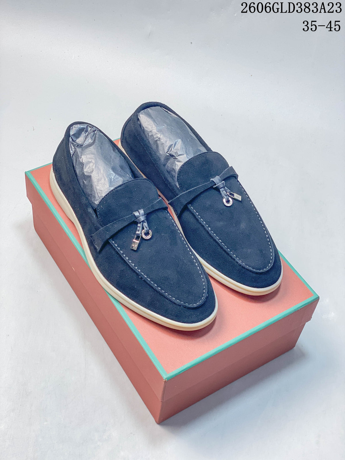 Pair of navy loafers with metal vamp details and light-colored soles
