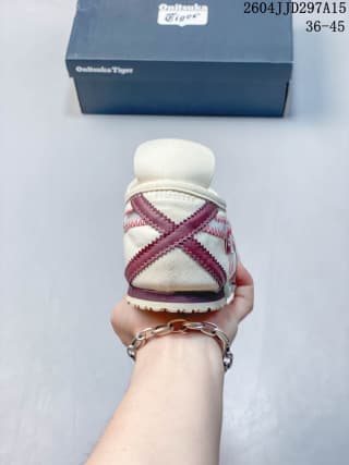 Rear view showing the heel structure, crossed red detailing, and branded shoe box.
