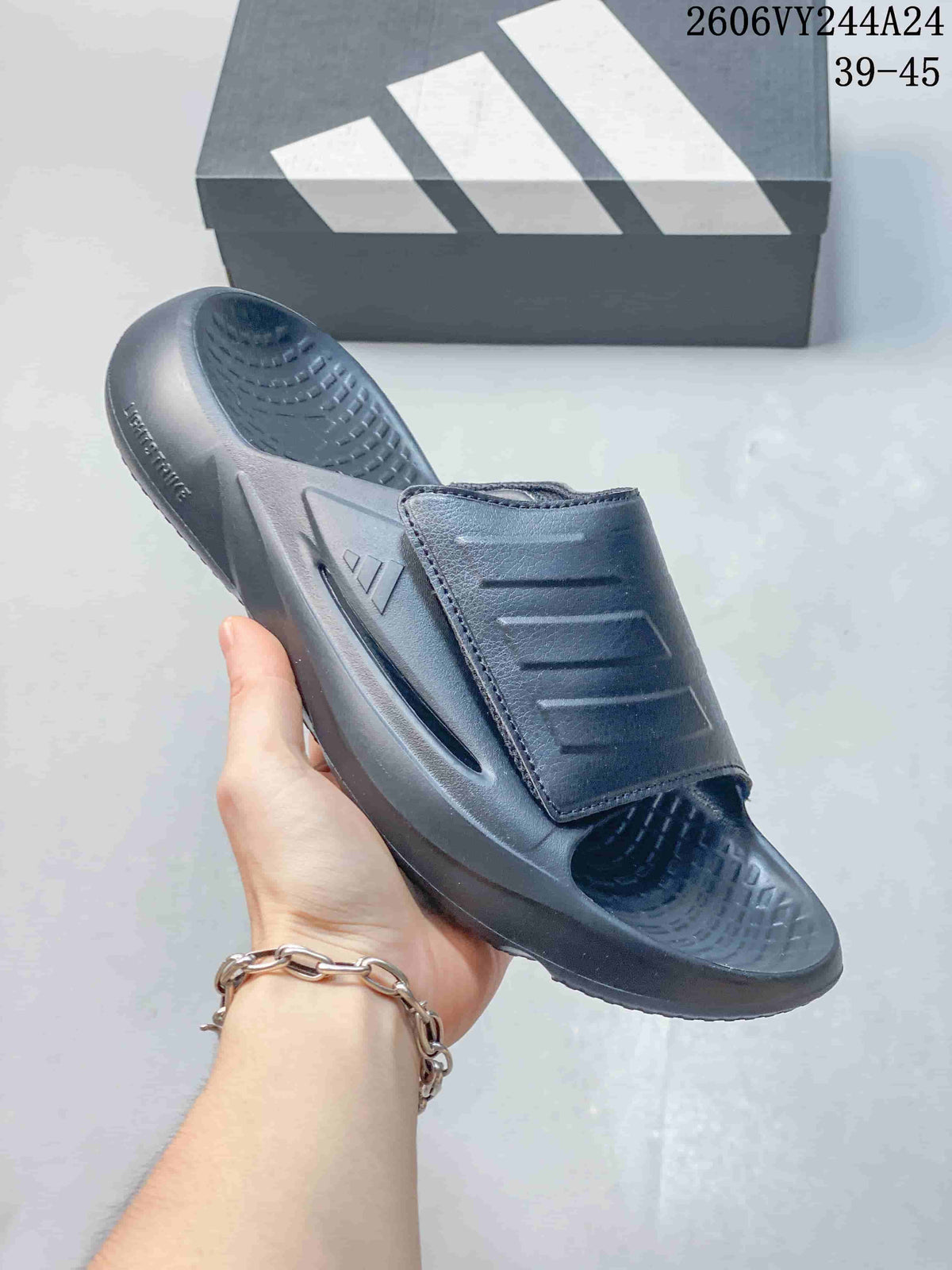 Close view of a dark gray adidas Lightblaze slide with a broad ridged strap; image overlay lists sizes 39–45.