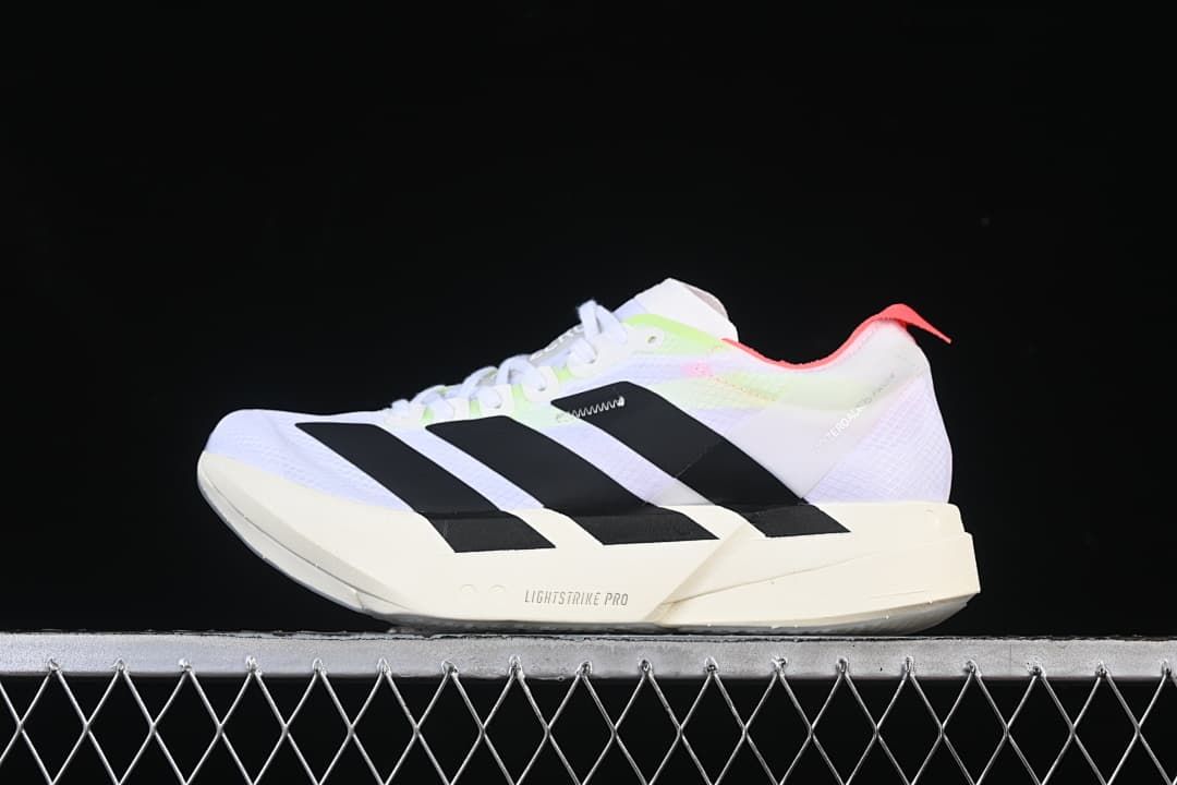 Side view of white Adidas Adizero Adios Pro 4 running shoes with black stripes and bright accent colors.