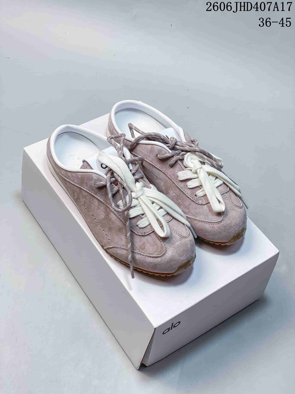 Pair of mauve Alo sneakers with white and gray laces on a box
