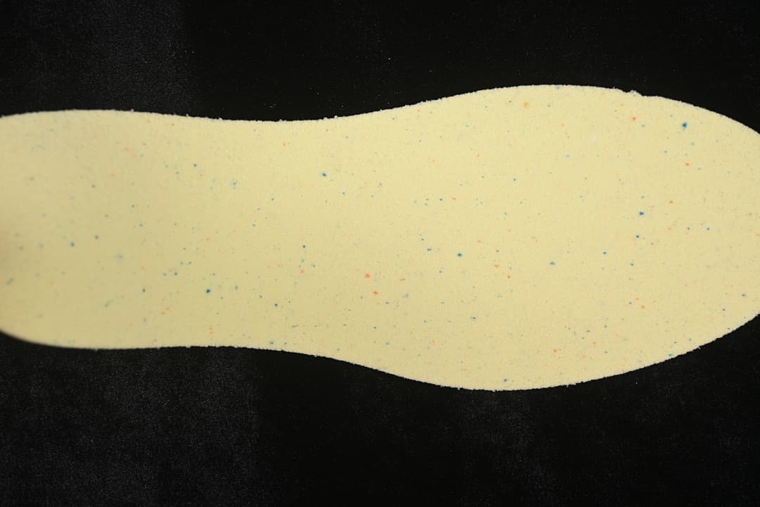 Light-colored shoe insert shown against a dark background