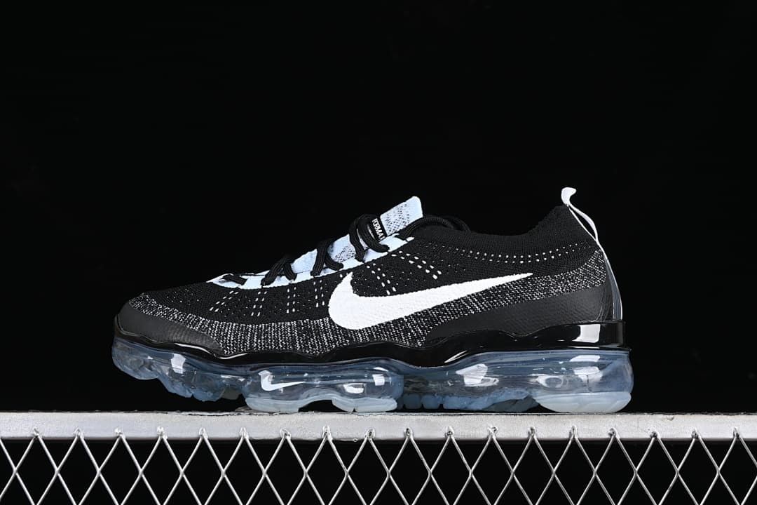 Side view of a black and white sneaker with a white Swoosh and translucent sole.