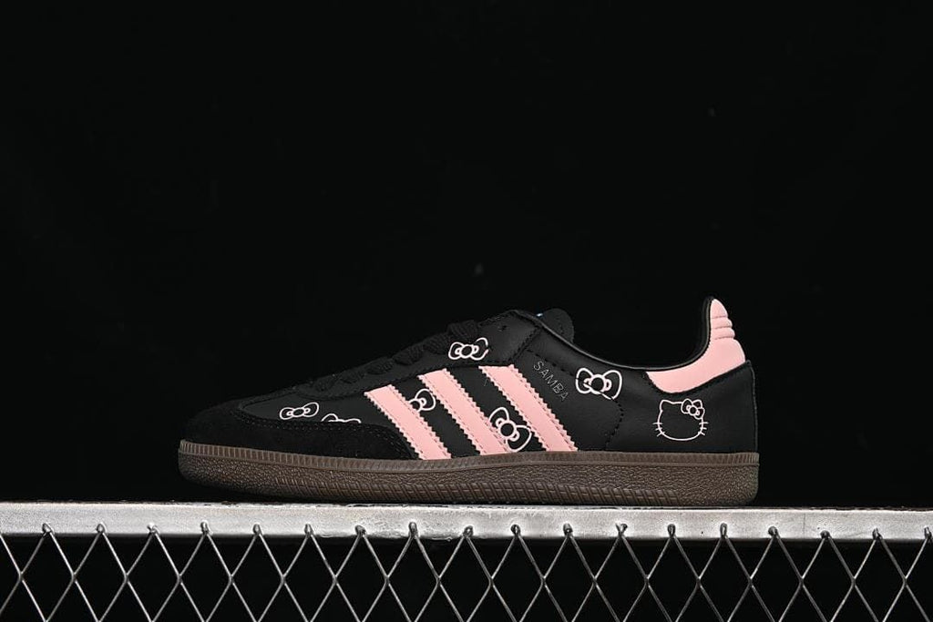 Side view of black Samba OG sneakers with pink stripes and character graphics