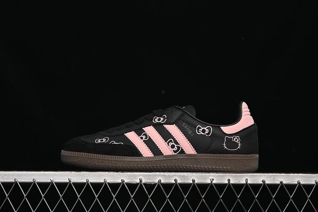 Side view of black Samba OG sneakers with pink stripes and character graphics