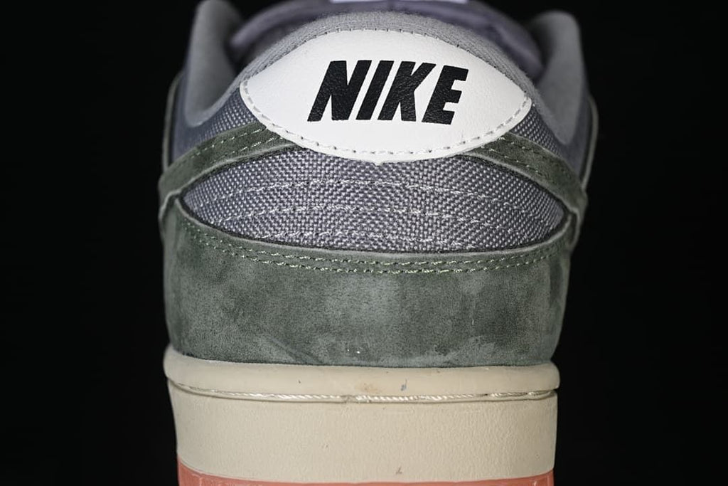 Rear view showing grey collar panels, olive-green overlays and white heel tab