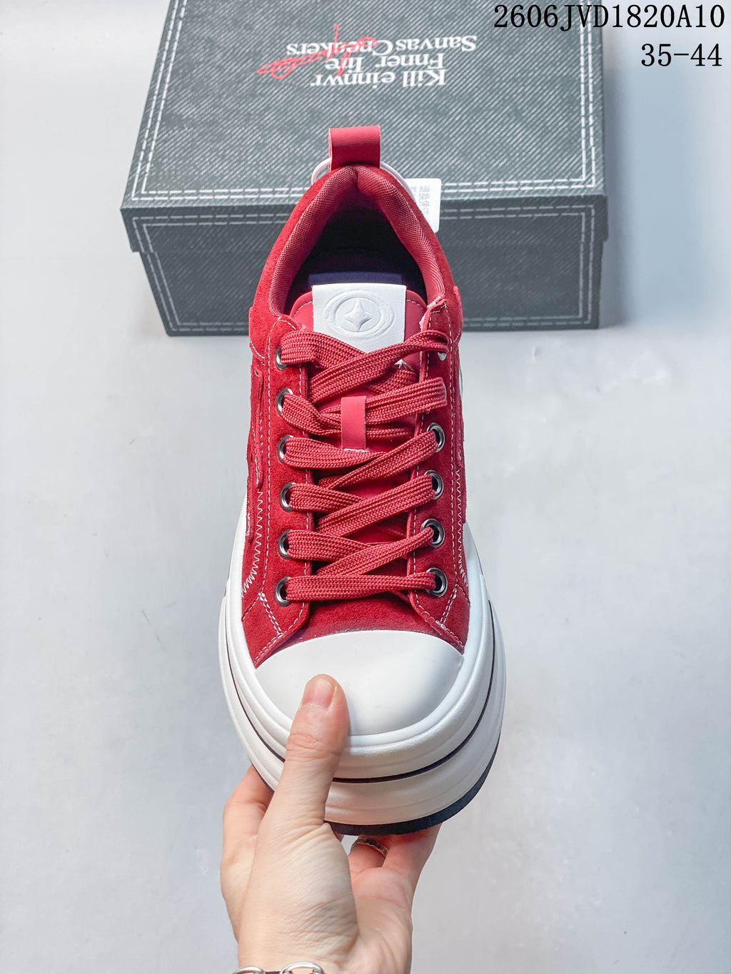 Front view of a red lace-up sneaker with a white toe cap