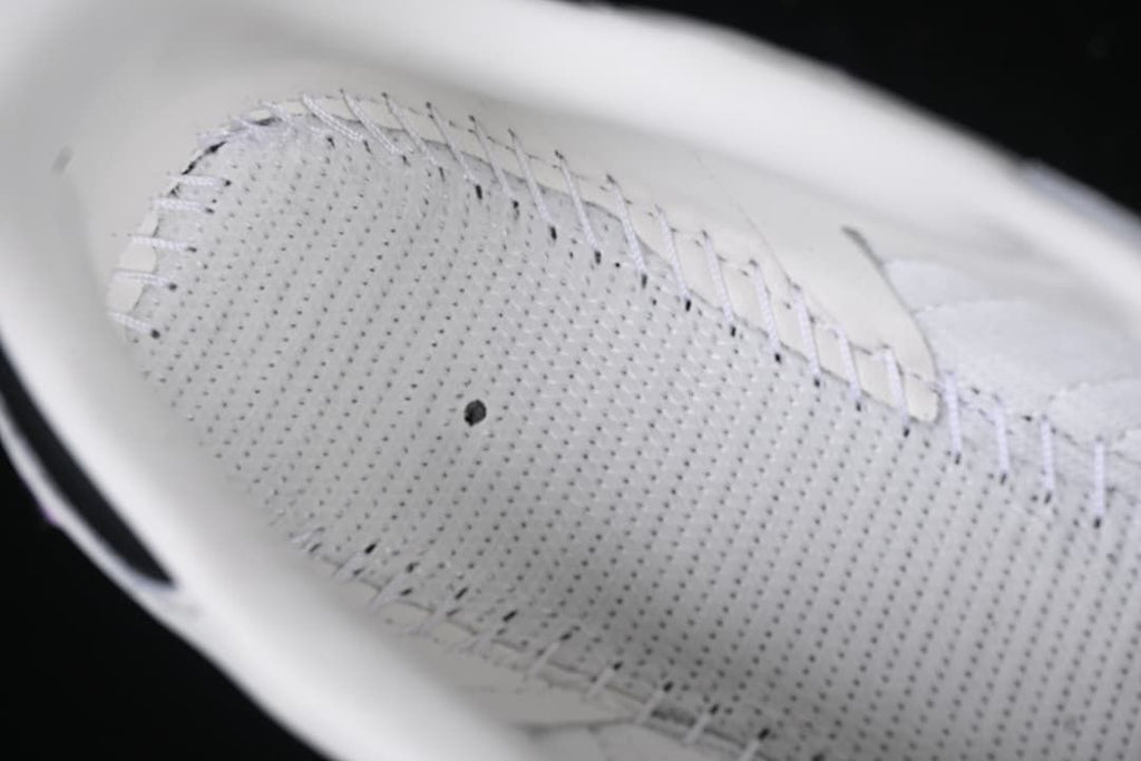 Close-up of perforated inner shoe panel and stitching