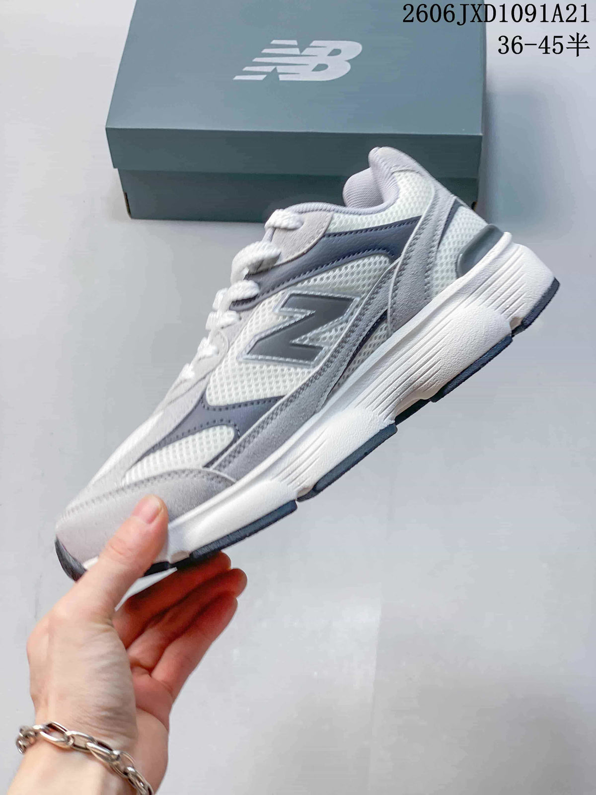 Side view of a gray and white New Balance sneaker with layered panels