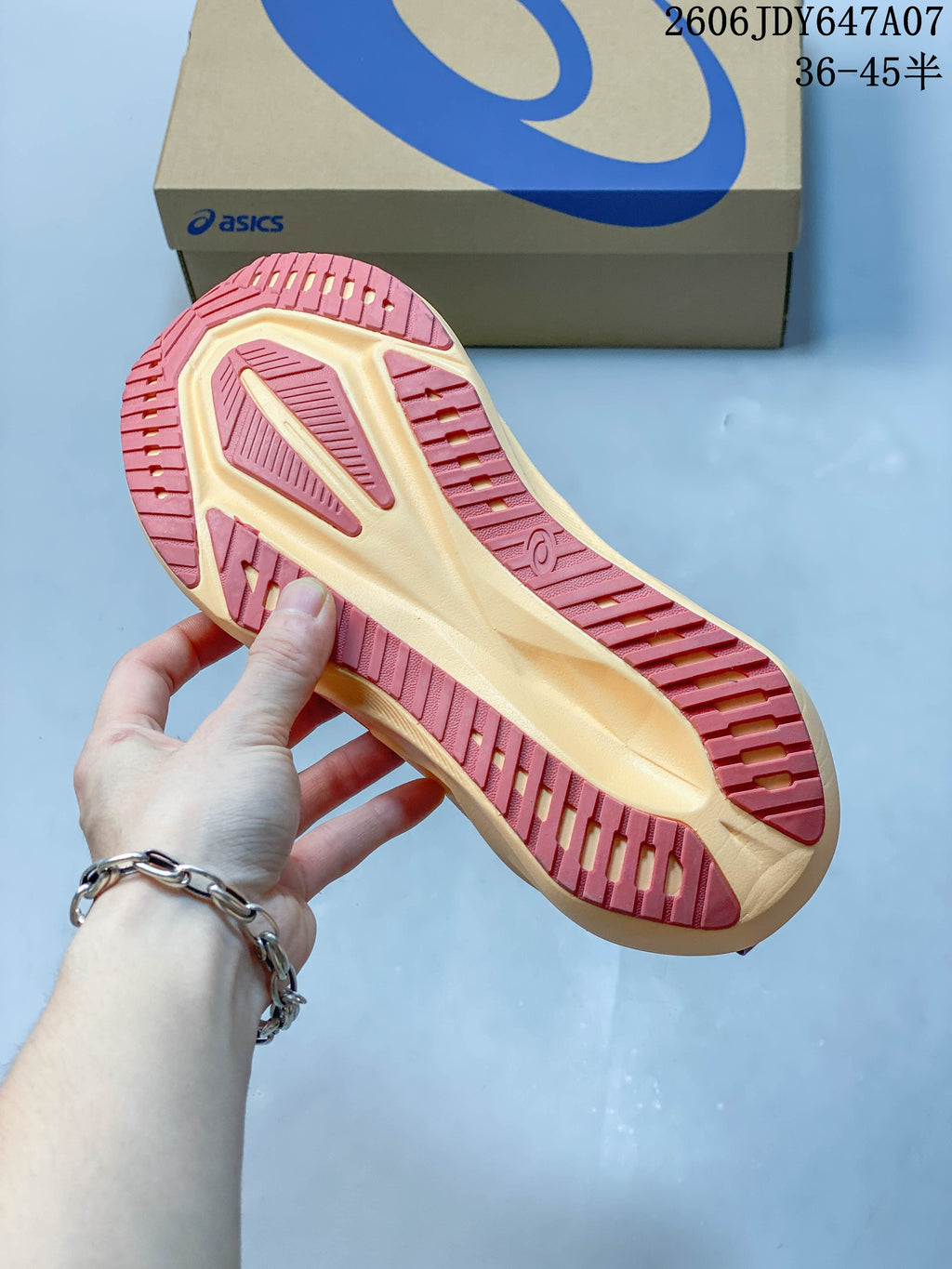 Underside of an ASICS Novablast 5 shoe showing its pink-and-pale-yellow outsole