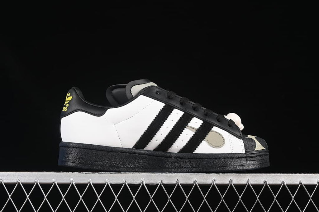 Side profile showing the white upper, black stripes, and black sole