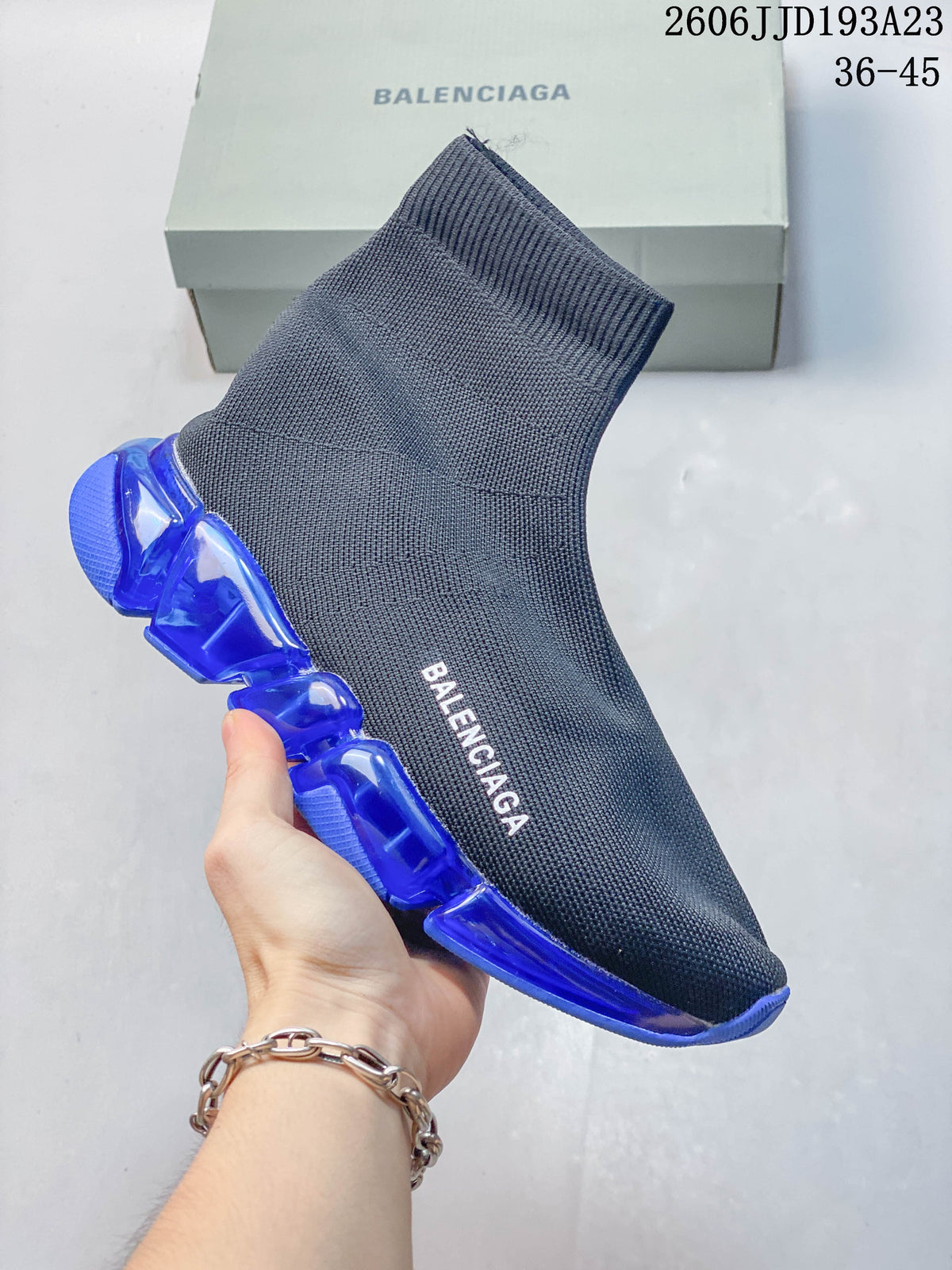 A gray-blue Balenciaga sock-style sneaker with a vivid blue segmented sole.