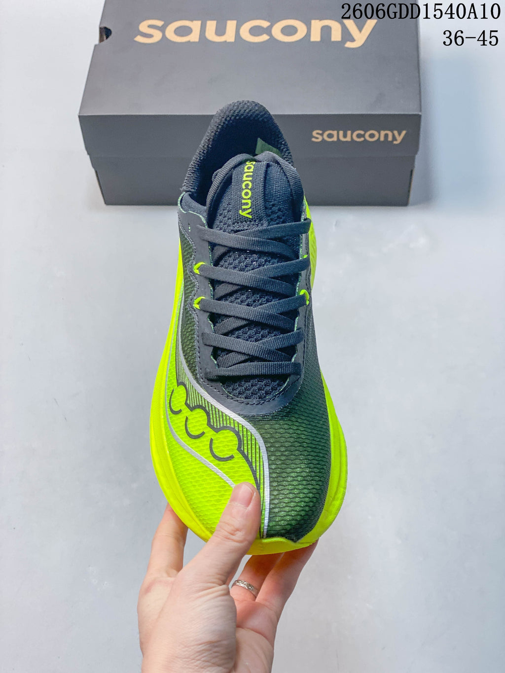 Front view of the running shoe with charcoal laces and neon yellow side accents.
