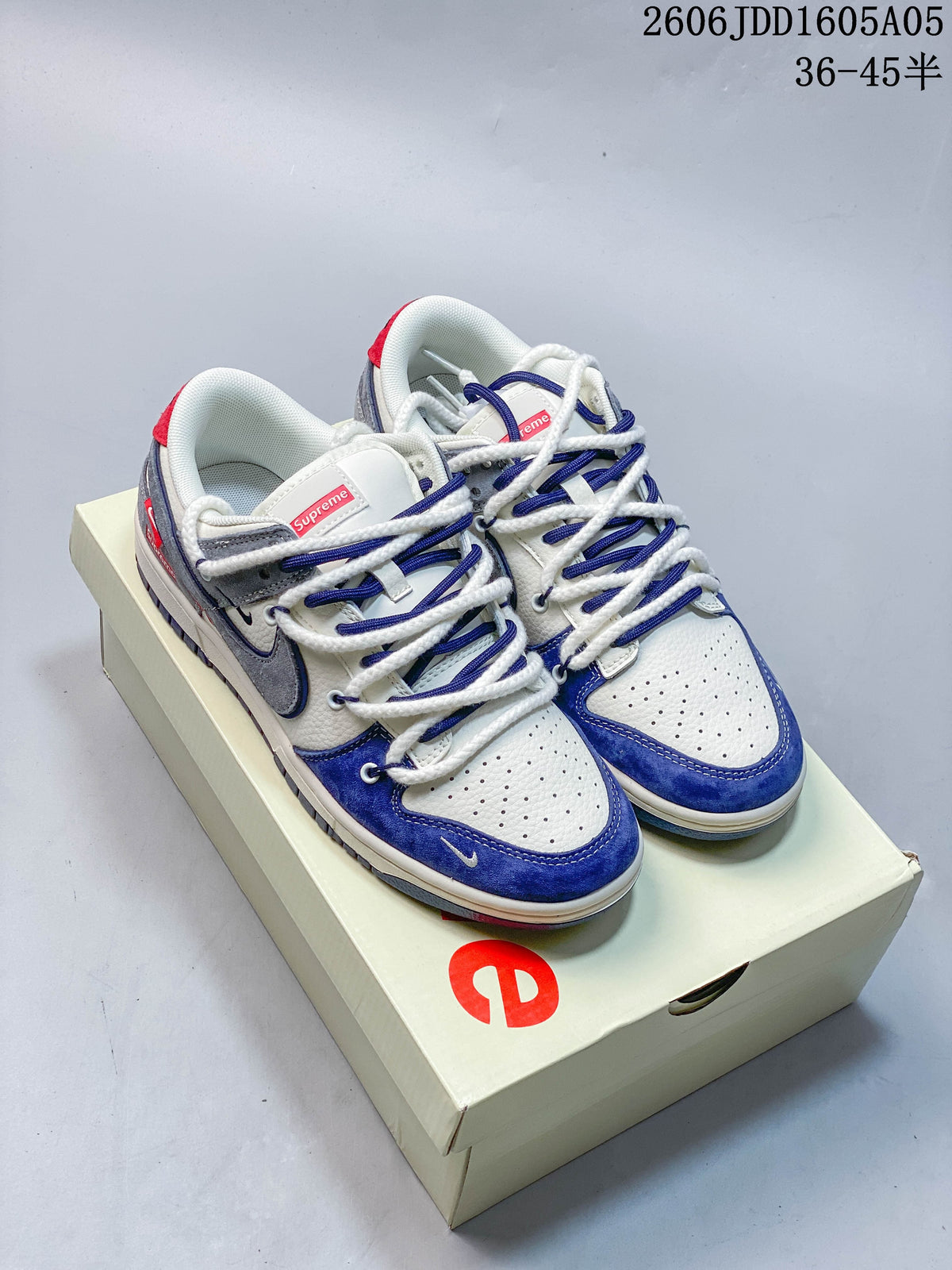 Pair of white, blue, and gray low-top sneakers with multiple lace cords, shown on a branded box