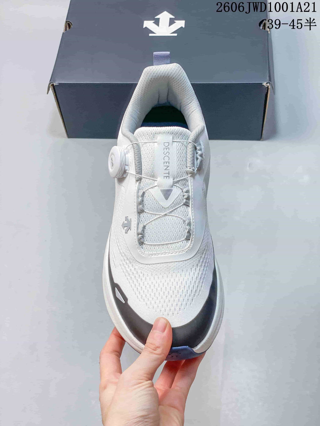Top view of a white DESCENTE sneaker showing its perforated upper and lace-up front