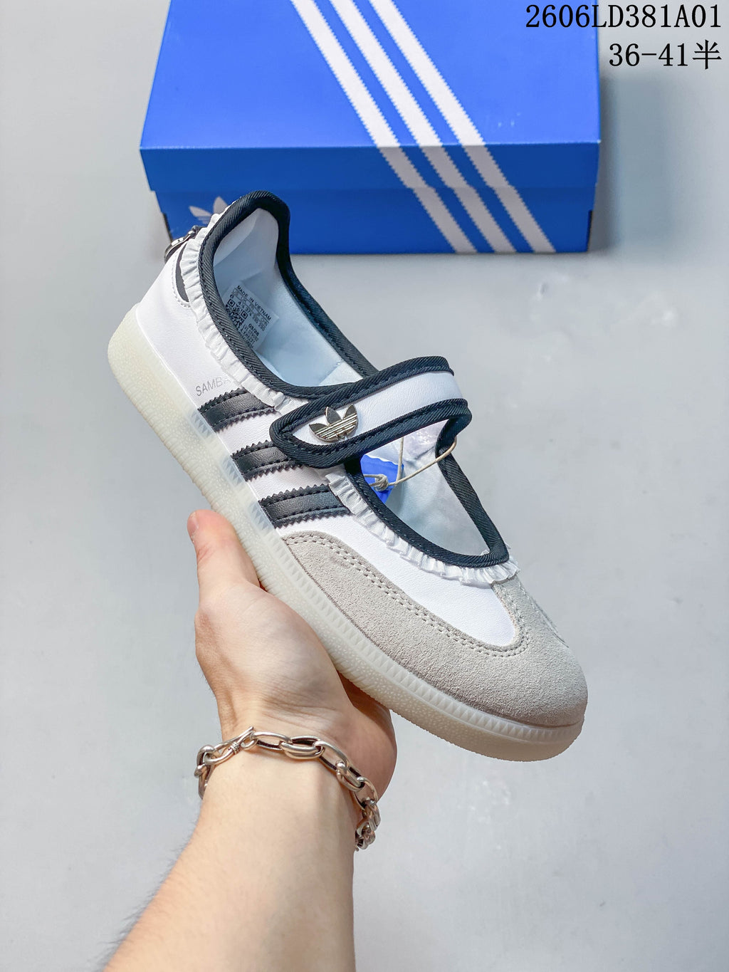 Angled view of the Adidas Samba Jane sneaker in white, gray, and dark trim