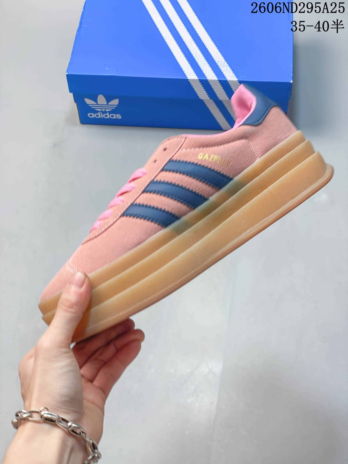 Side view of the pink sneaker with blue stripes, a gold Gazelle marking, and a layered gum-colored sole.