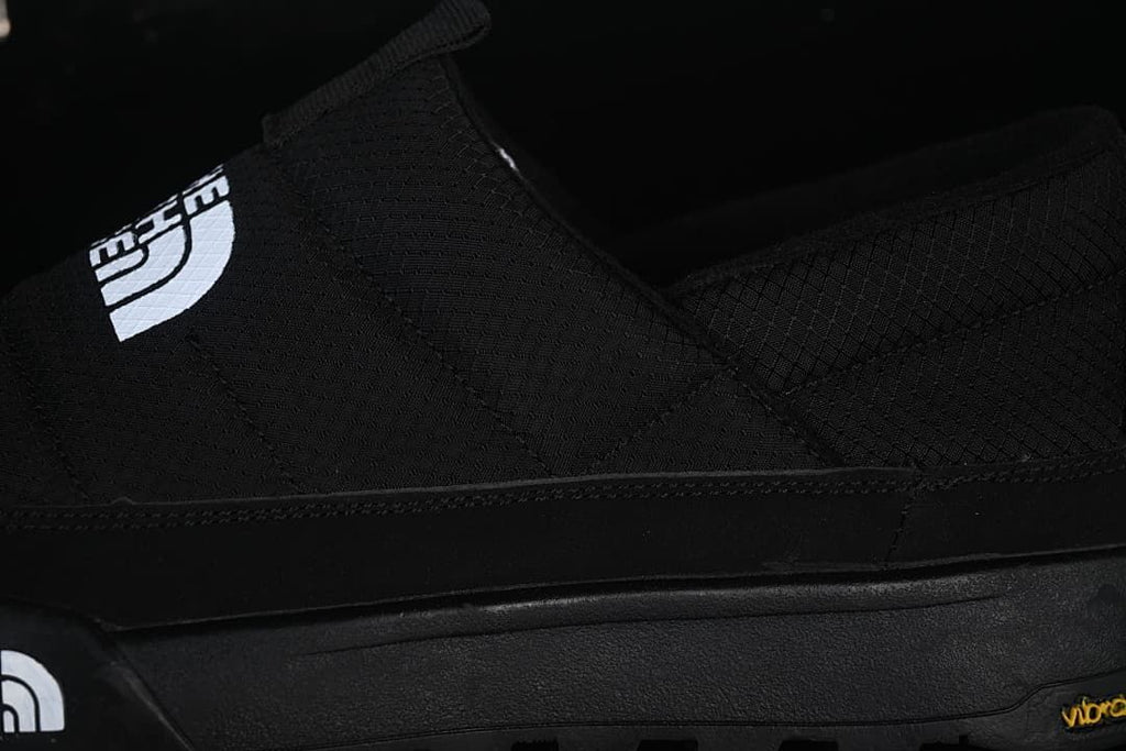 Close-up of the black upper, logo, and sole
