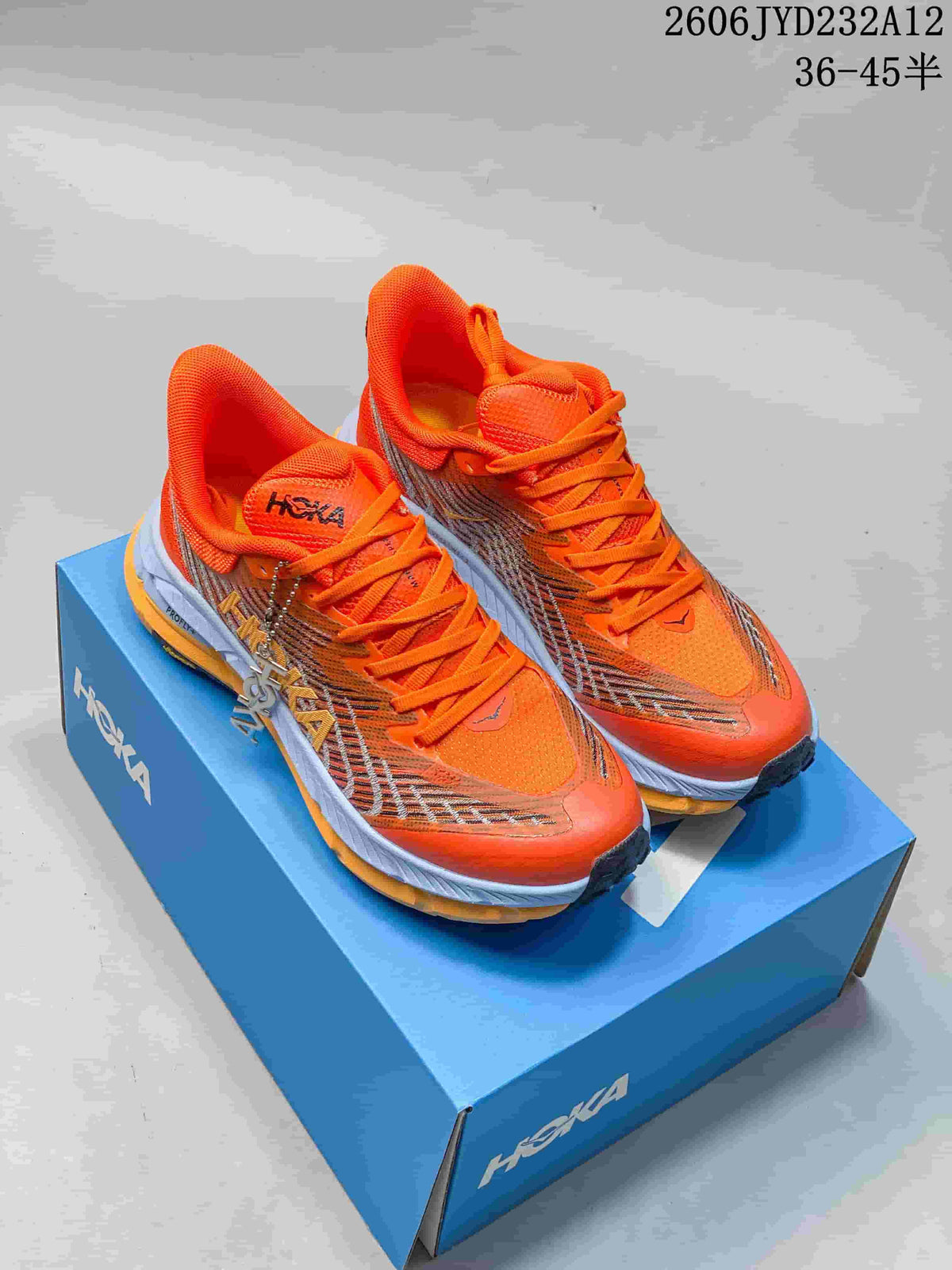 Pair of orange HOKA Mafate Speed 4 shoes shown from above on a blue shoebox