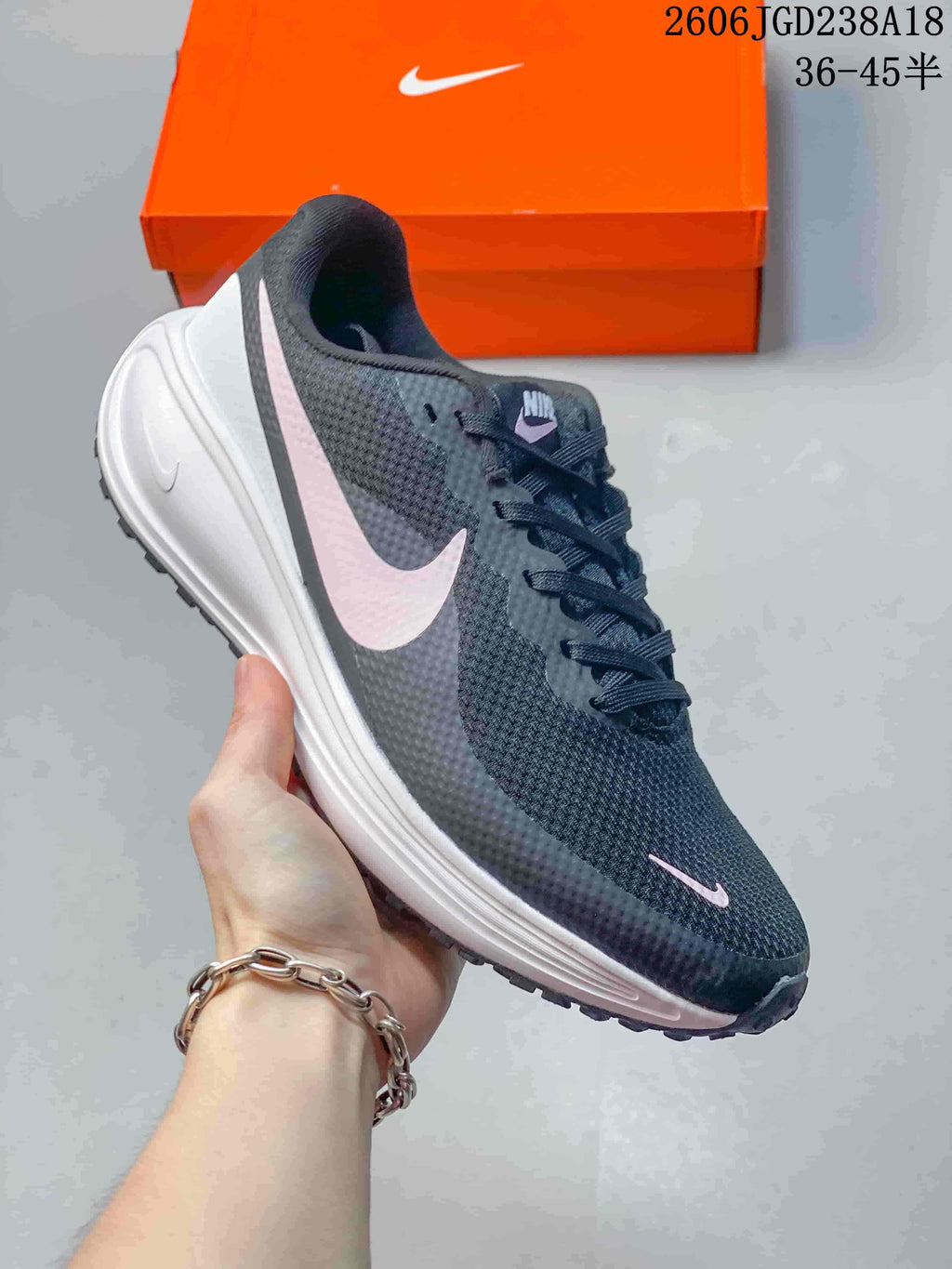 Angled side view of the charcoal running shoe with pale pink Swoosh details