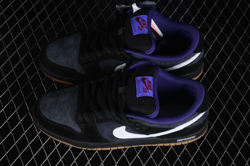 Top-down view of a pair of Nike SB Dunk Low sneakers with purple collars and white side Swooshes.