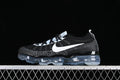 Side view of black and white VaporMax-style sneakers with a white Swoosh and translucent sole.