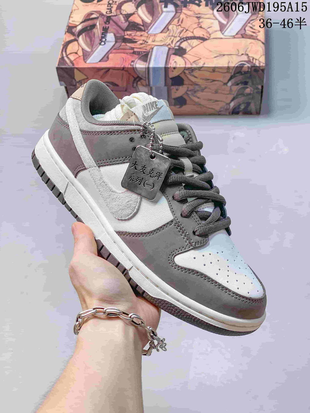 Nike SB Zoom Dunk Low sneaker in gray, taupe, and white with spare laces pictured.