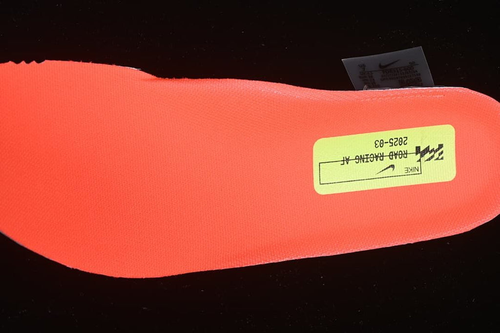 Bright coral shoe insert with a Nike road racing label