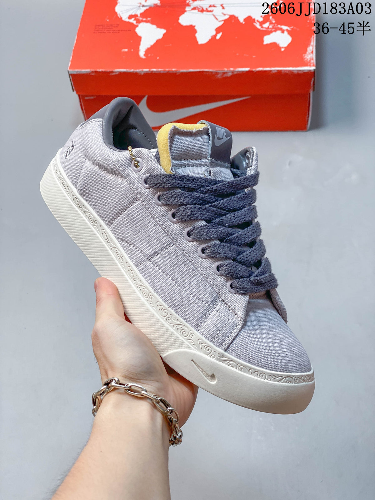 Light gray low-top lace-up sneaker with a white decorated midsole
