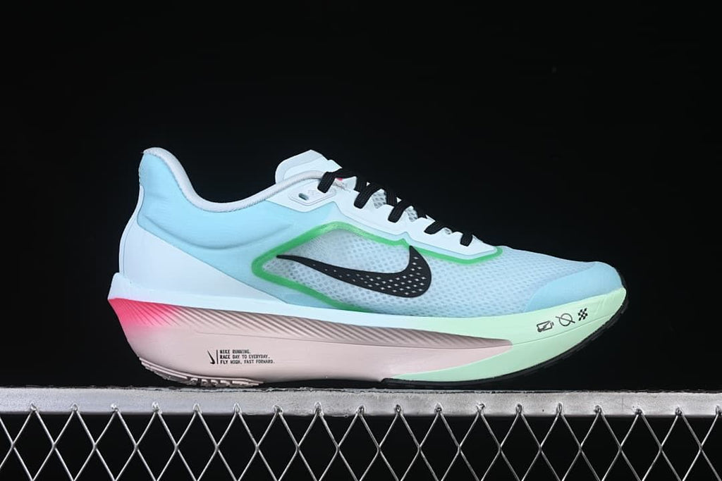Side profile of the shoe showing its pale blue upper, black Swoosh, green trim, and pink midsole.